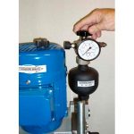 Vista de la mano del operador regulando la presión en el manómetro, actuando sobre mando regulador.